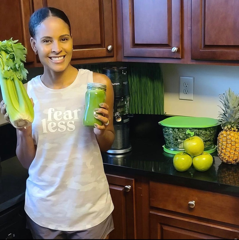 Woman making green vegetable juice in juicer using celery, apples, pineapples and kale.